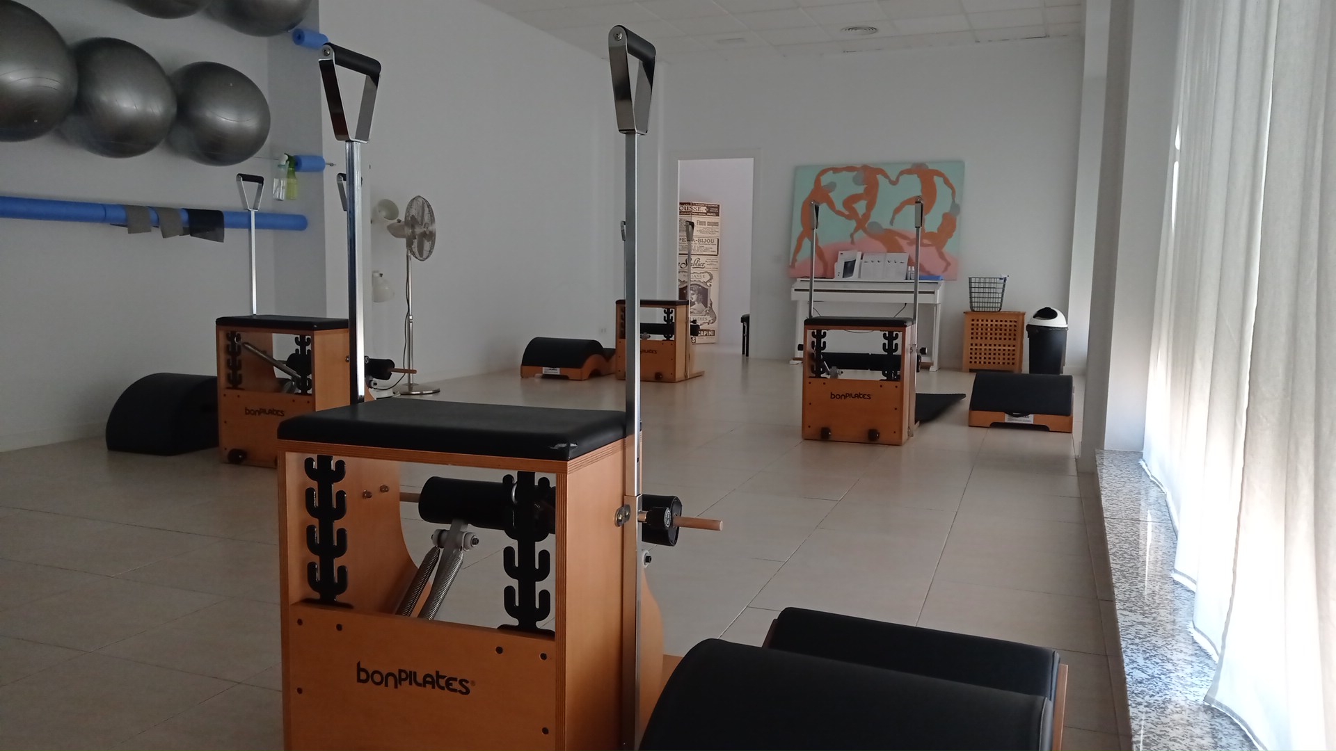 Sillas de pilates (wunda chair) de madera bonPilates, con fitballs y rulos al fondo