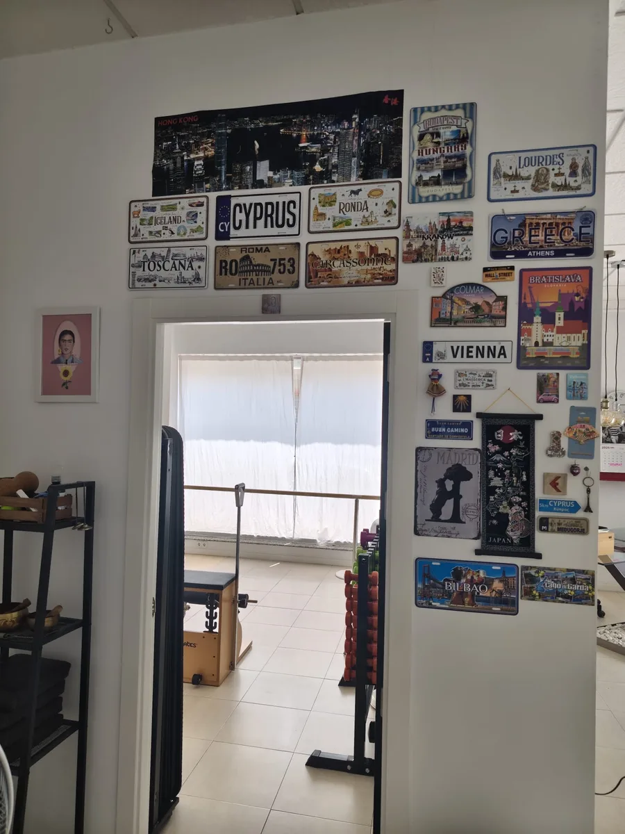 Puerta del estudio rodeada de matrículas de recuerdo de muchos países, junto a una lámina de Frida Kahlo