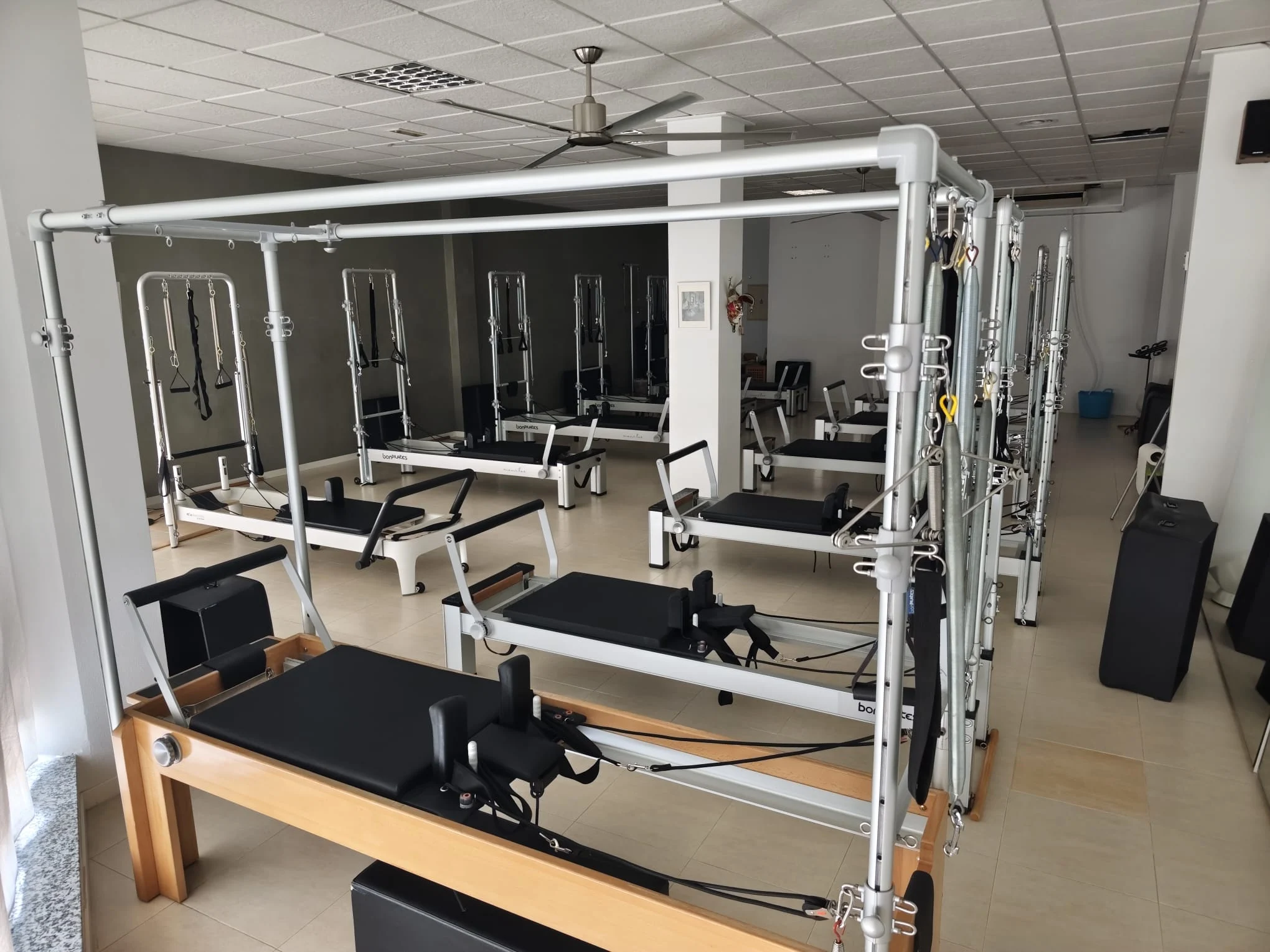 Sala de mi'a pilates studio en Totana: una torre cadillac en primer plano y la fila de reformers al fondo