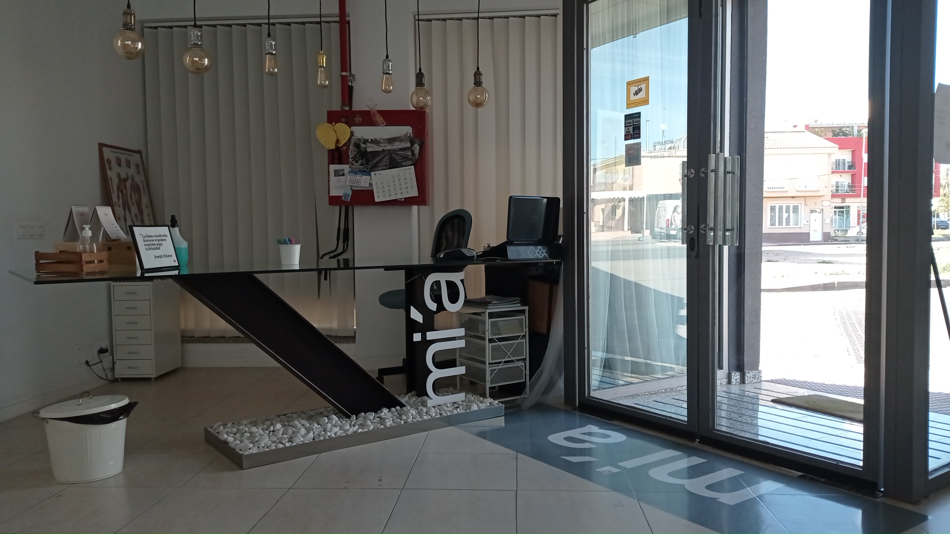Recepción con mesa de cristal, las letras mi'a y bombillas de filamento